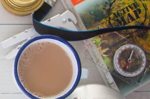 A cup of tea pictured from above, next to an expedition book